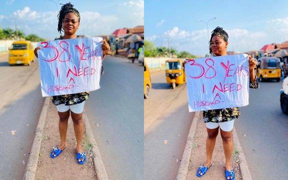 ‘I Need a Husband’! – Beautiful Lady Cries Out on the Road With With Placard (Photo)