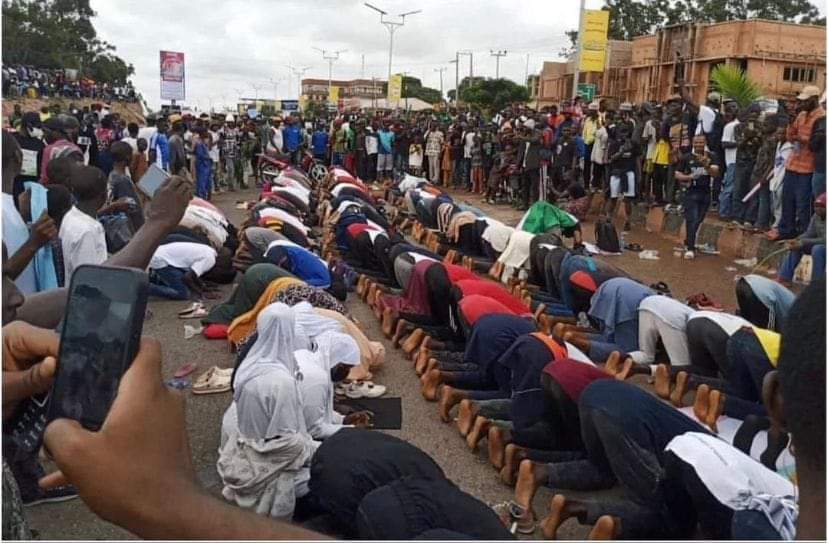 Christians Guarding Muslims While They Observe the Zuhr Prayer at the Protest Ground in Jos