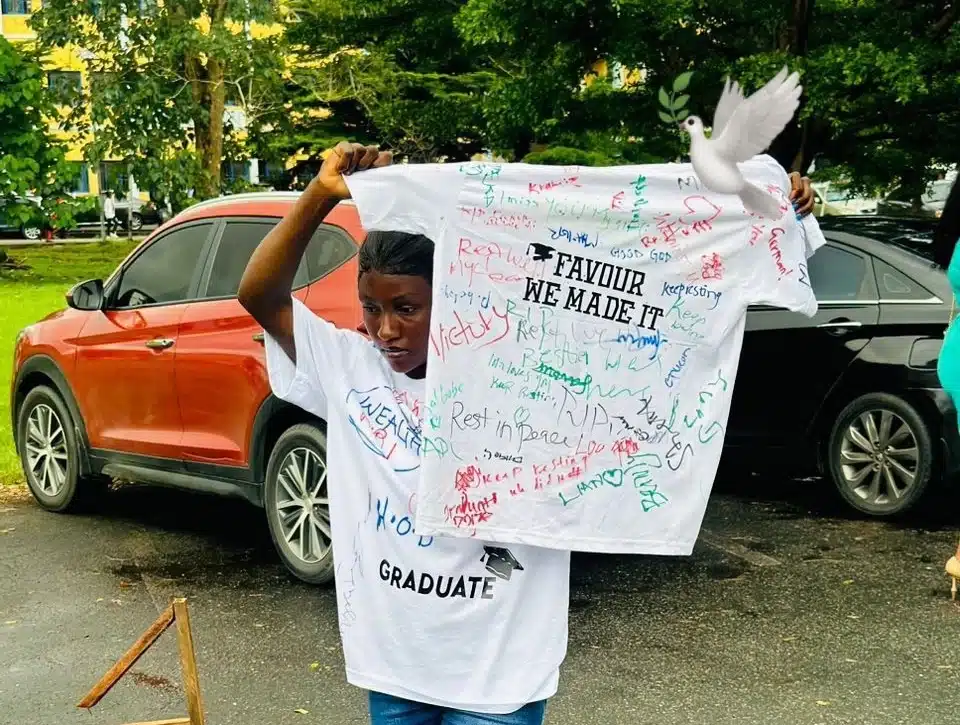 Nigerian lady signs out of university, holds shirt in tribute to late coursemate